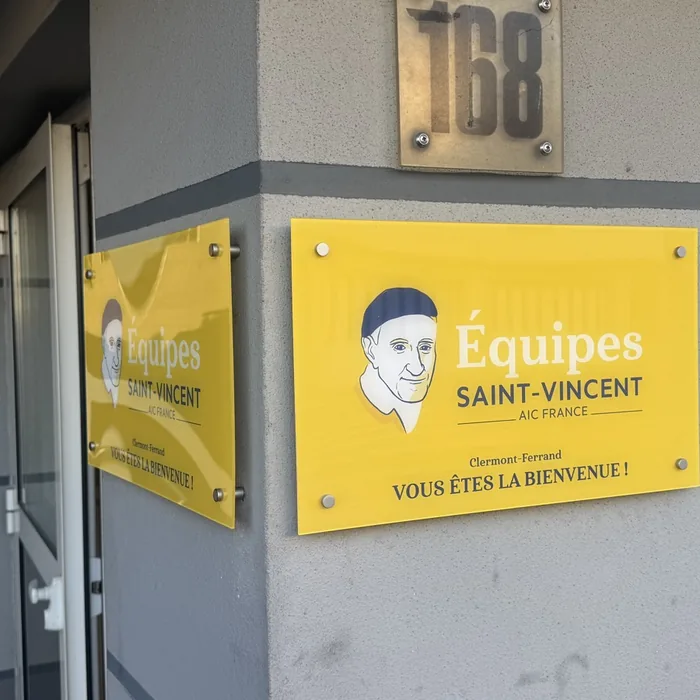 Panneaux de signalétique extérieure jaunes posés à l'entrée des Équipes Saint-Vincent à Clermont-Ferrand